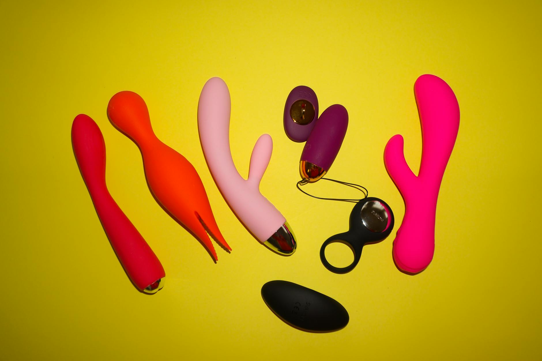 Hands holding pastel-colored silicone vibrators, representing solo pleasure and self-reconnection after a breakup