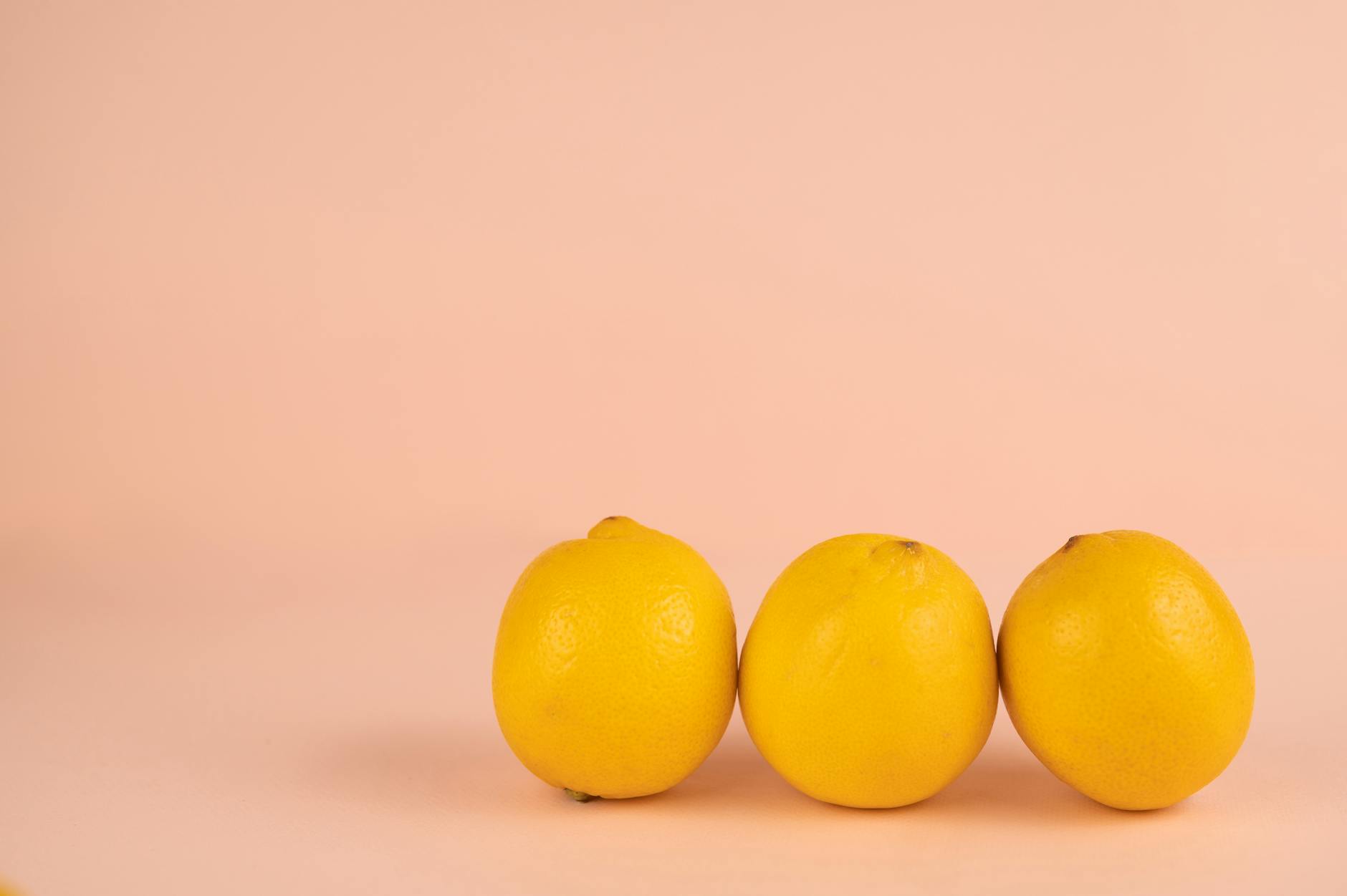 Bright yellow lemons on a pastel background, symbolizing fresh communication about pleasure