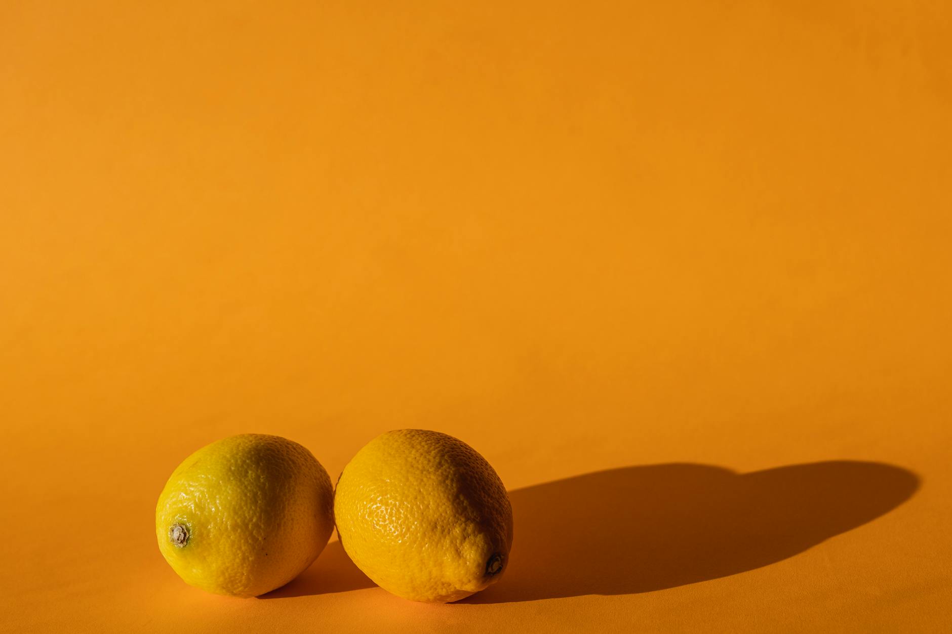 Bright yellow lemons arranged on a vibrant yellow background, symbolizing freshness and renewal